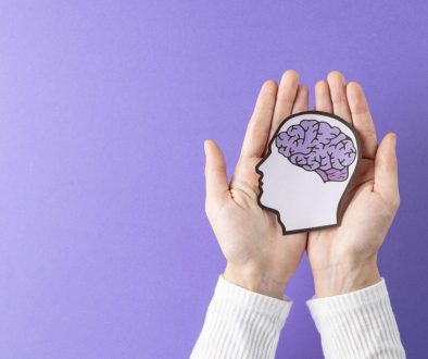 Hands holding image of paper head with brain