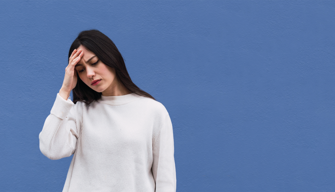 Woman with her hand on her head distresssed