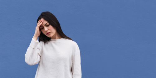 Woman with her hand on her head distresssed